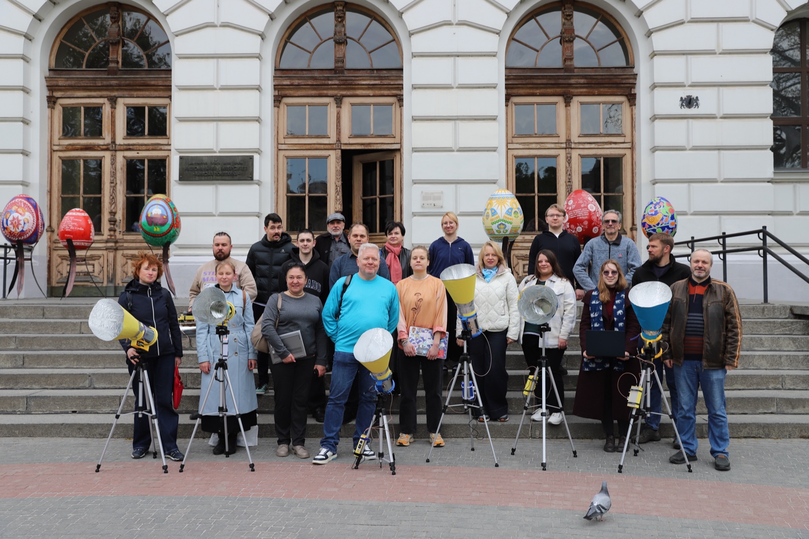 Workshop participants with their self-built radio telescopes on tripods in front of the main building of Lviv Polytechnic National University.